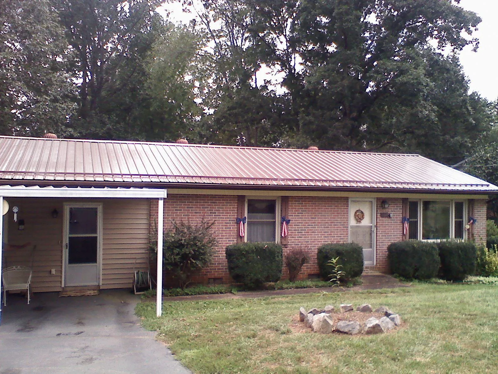 Bronze metal roof and carport on a brick ranch home — Roof Repair work by our crew in New Lisbon